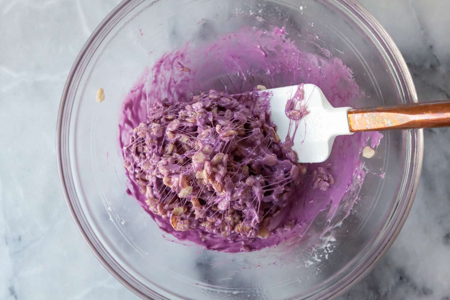 Rainbow Rice Krispie Treats Mixed with Purple Marshmallow Mixture in Bowl
