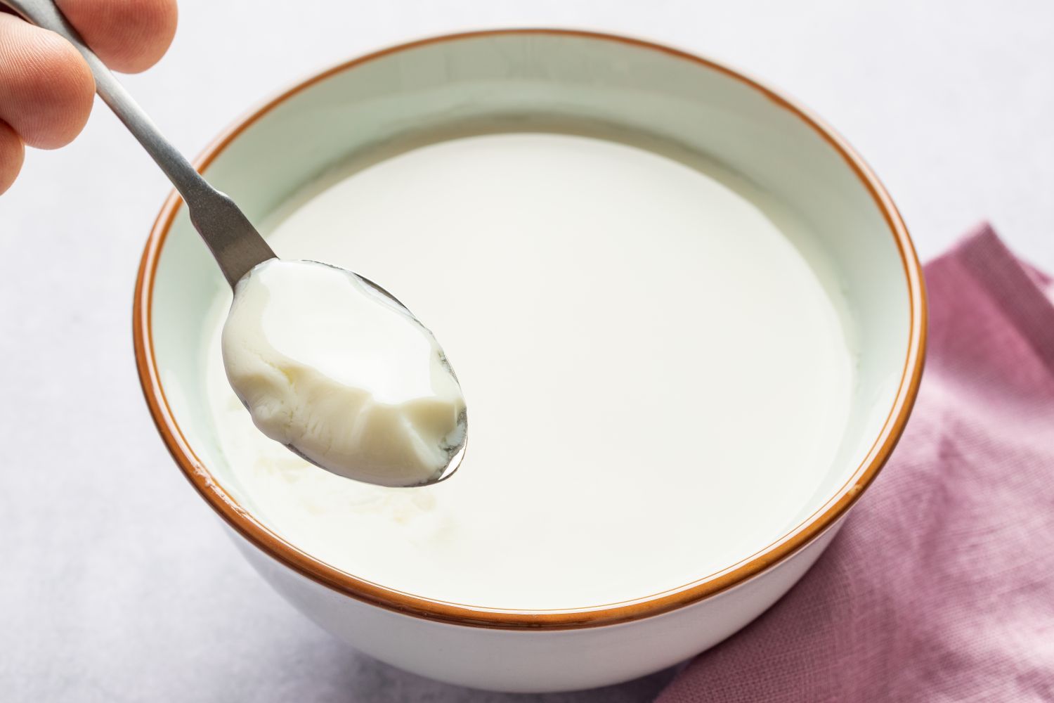 A bowl of ginger milk pudding with a spoon lifting a portion