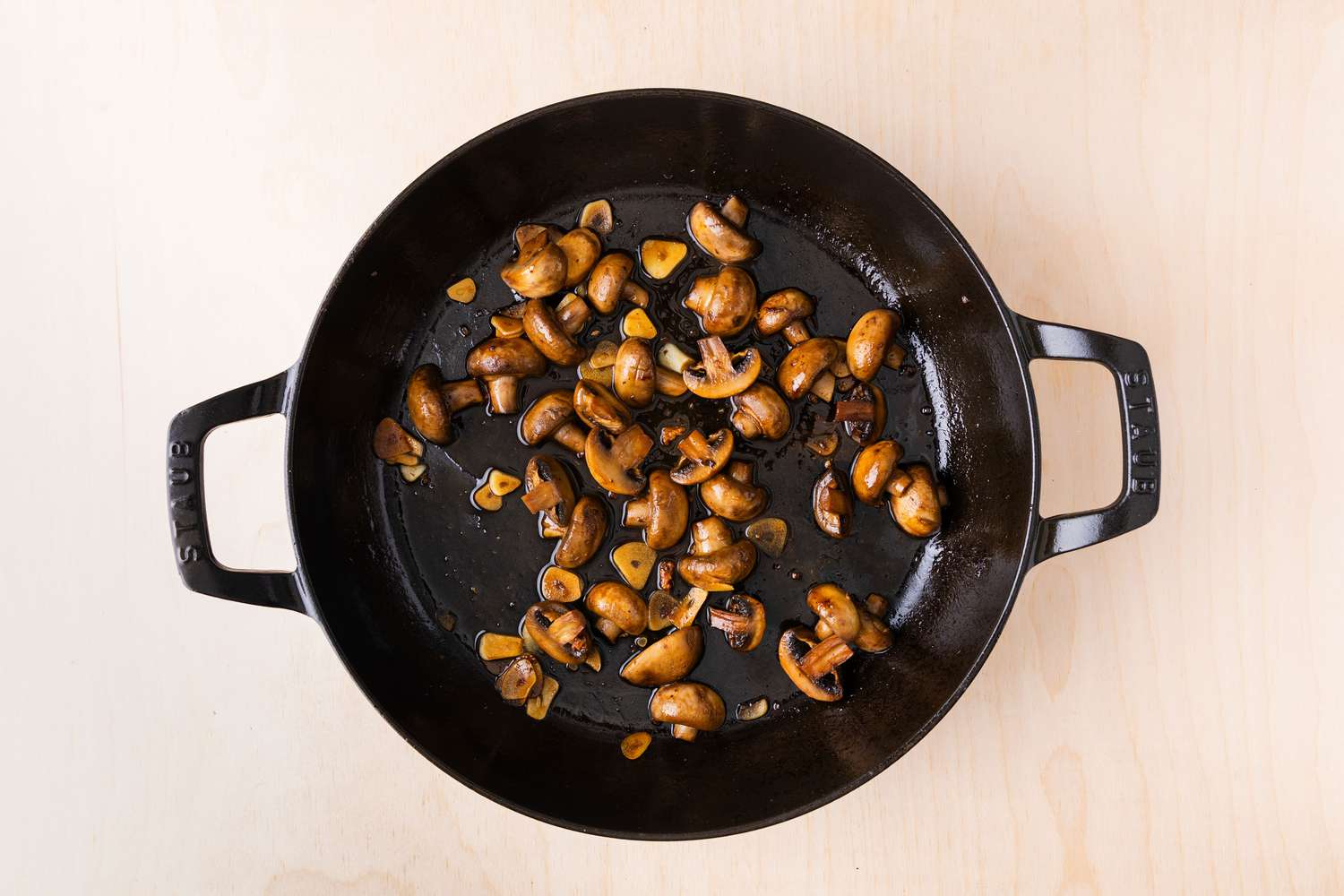 halved button mushrooms browning in a large cast iron skillet for Chicken Supreme