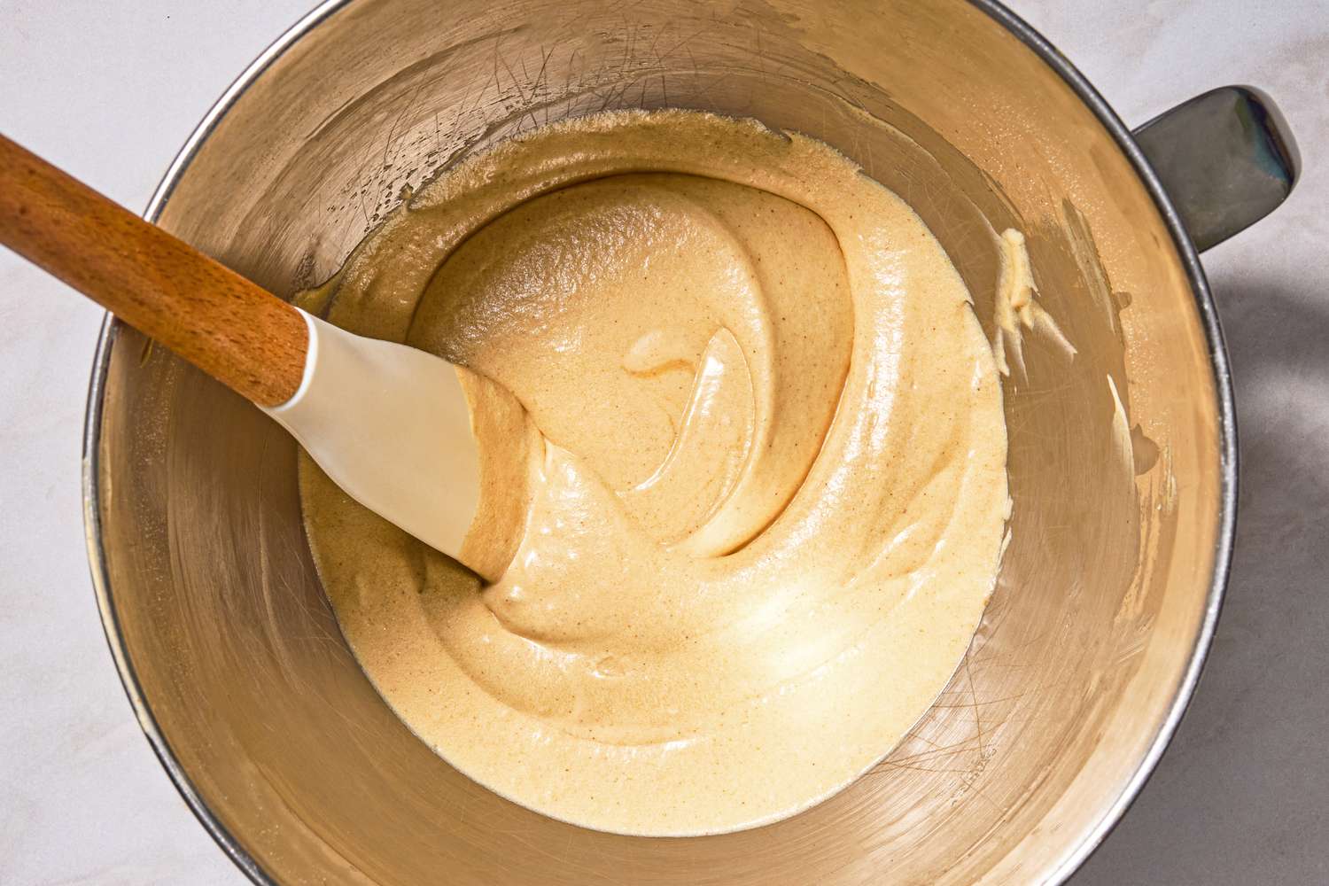 overhead view of mixing bowl with peanut butter mixture and spatula for Chocolate-Peanut Butter Delight