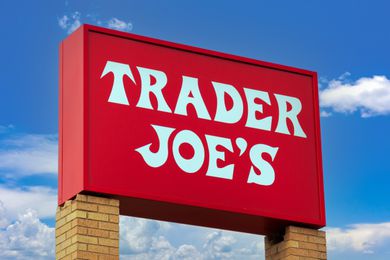 Trader Joe's store sign on a brick support against a cloudy sky