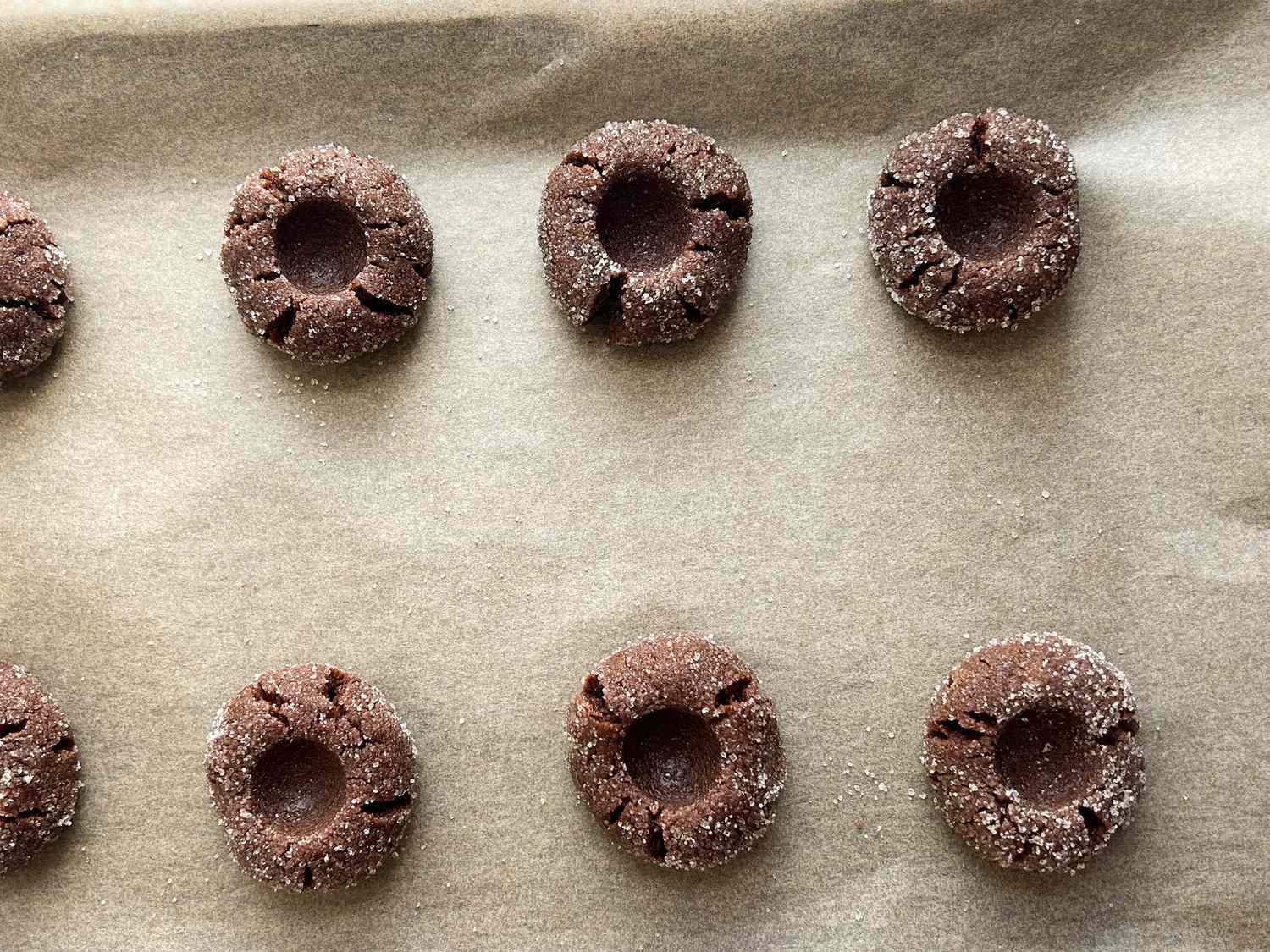 Tray with chocolate thumbprint cookies ready for baking