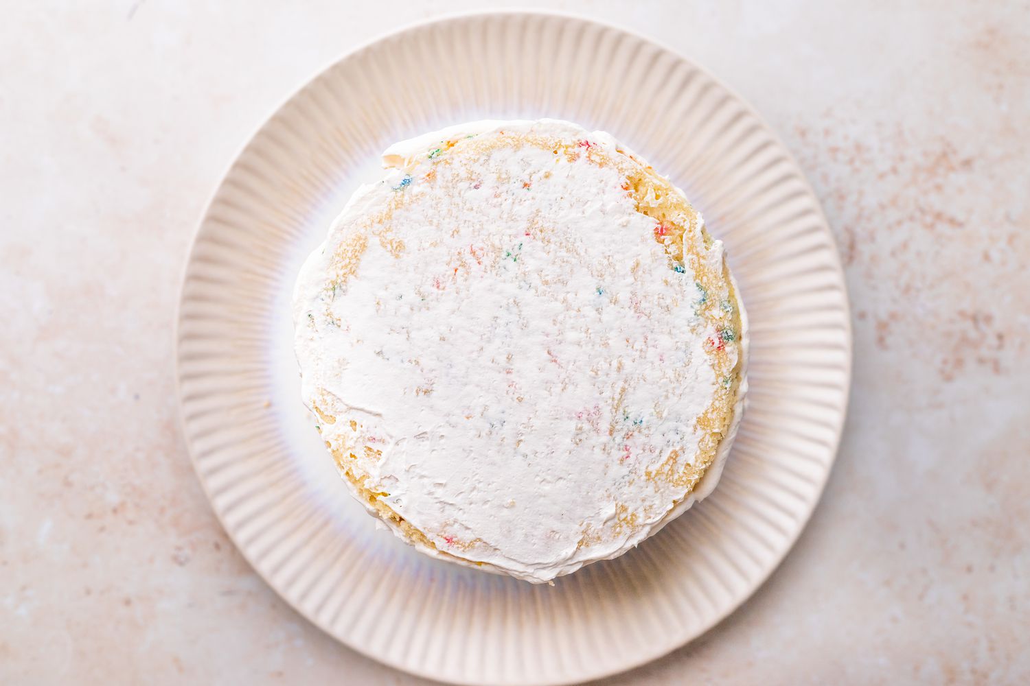 Crumb Coat Added to Unicorn Cake on a Plate 