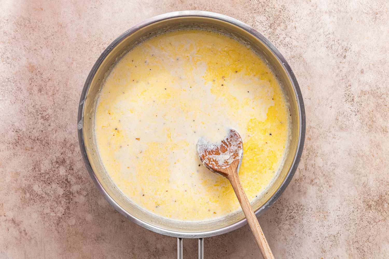 Pot of Creamy Cavatappi Sauce With a Wooden Spoon