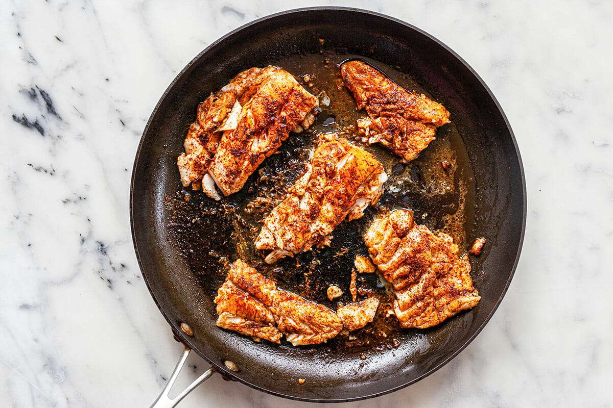 Fish browning in a skillet for the best fish tacos.