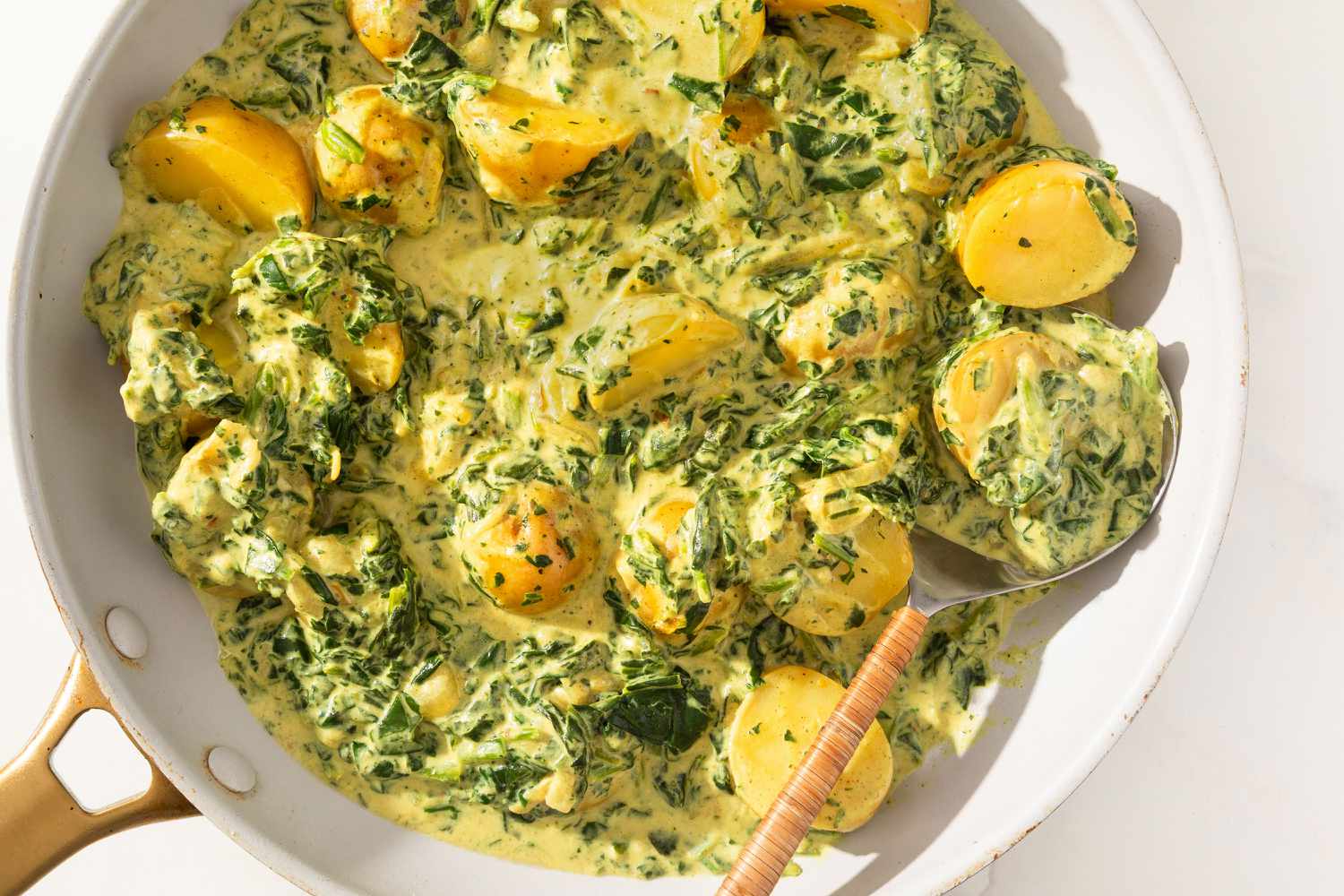 5-Ingredient Curried Potatoes in a pan with a serving spoon