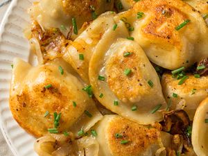 Plate of cooked pierogies topped with chopped chives