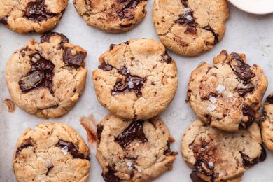 The best vegan chocolate chip cookies with flaky salt on top on a baking sheet.