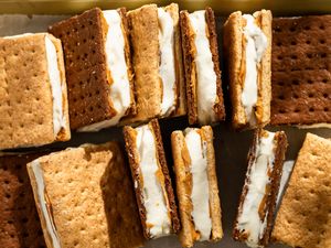 Several frozen graham cracker sandwiches filled with cream and peanut butter arranged on a surface