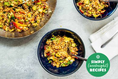 Vegetable fried rice in a blue bowl with a fork