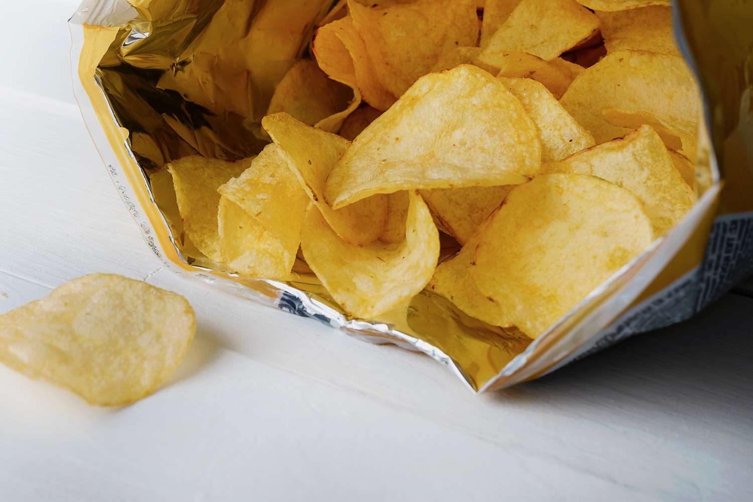 Bag of potato chips spilling onto a table