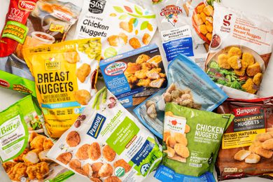 Different brands of chicken nuggets (still in the bag) splayed on a counter