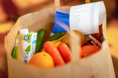bag of groceries with a receipt sticking out of the bag