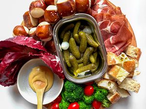 Overhead view of a tray of various foods to dip in cheese fondue