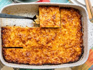 Casserole Dish of Trinidadian Macaroni Pie Cut into Individual Servings with One Piece Lifted Using a Spatula