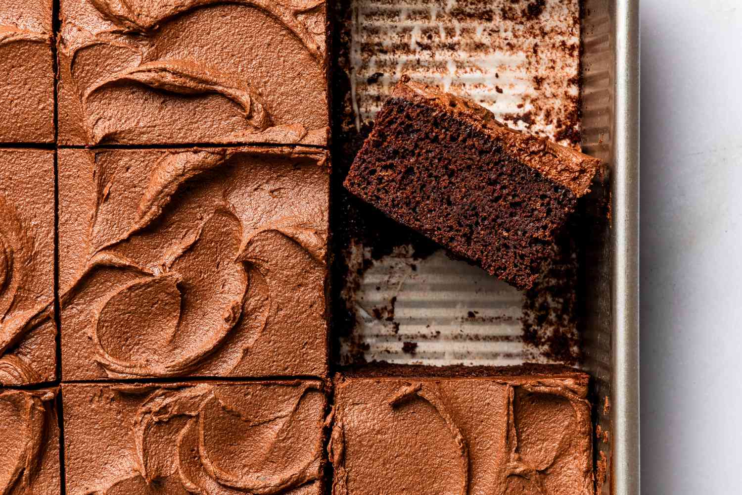 Devil's food cake in a baking pan (sliced and one slice facing up to show cross-section)