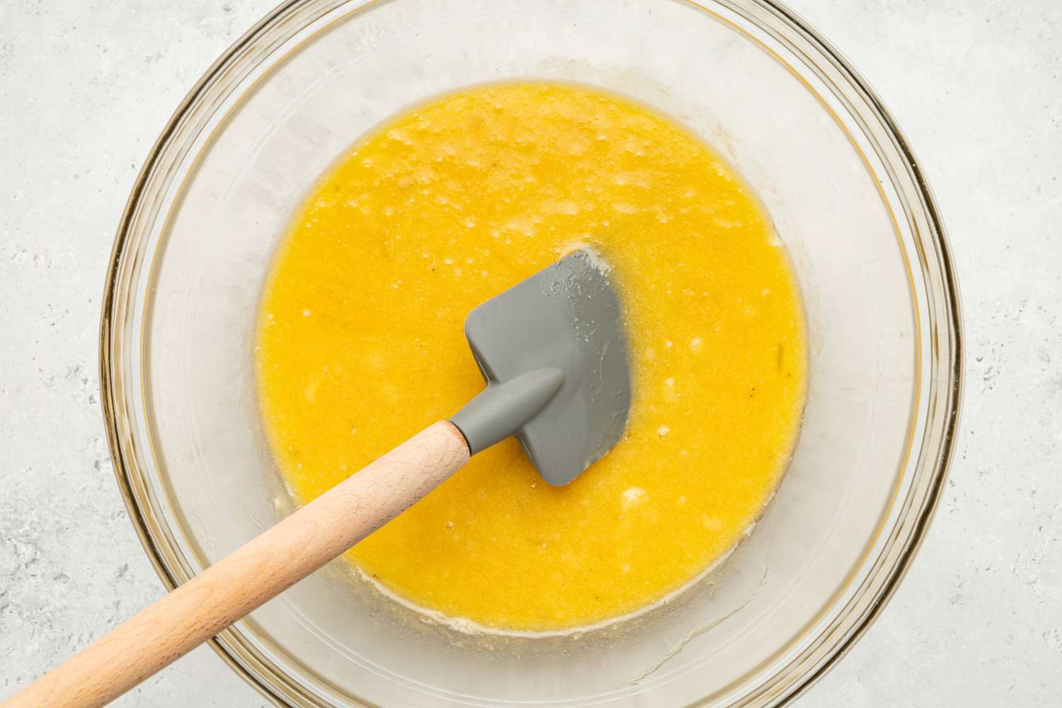 Wet Ingredients Mixed Into Bowl of Mashed Bananas Using a Spatula for Chocolate Banana Bread Coffee Cake