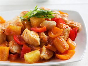 Sweet Sour Chicken on a white plate topped with green onions