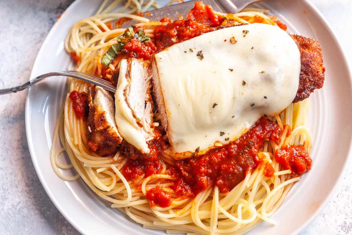 Baked Chicken Parmesan in a Skillet serve over spaghetti