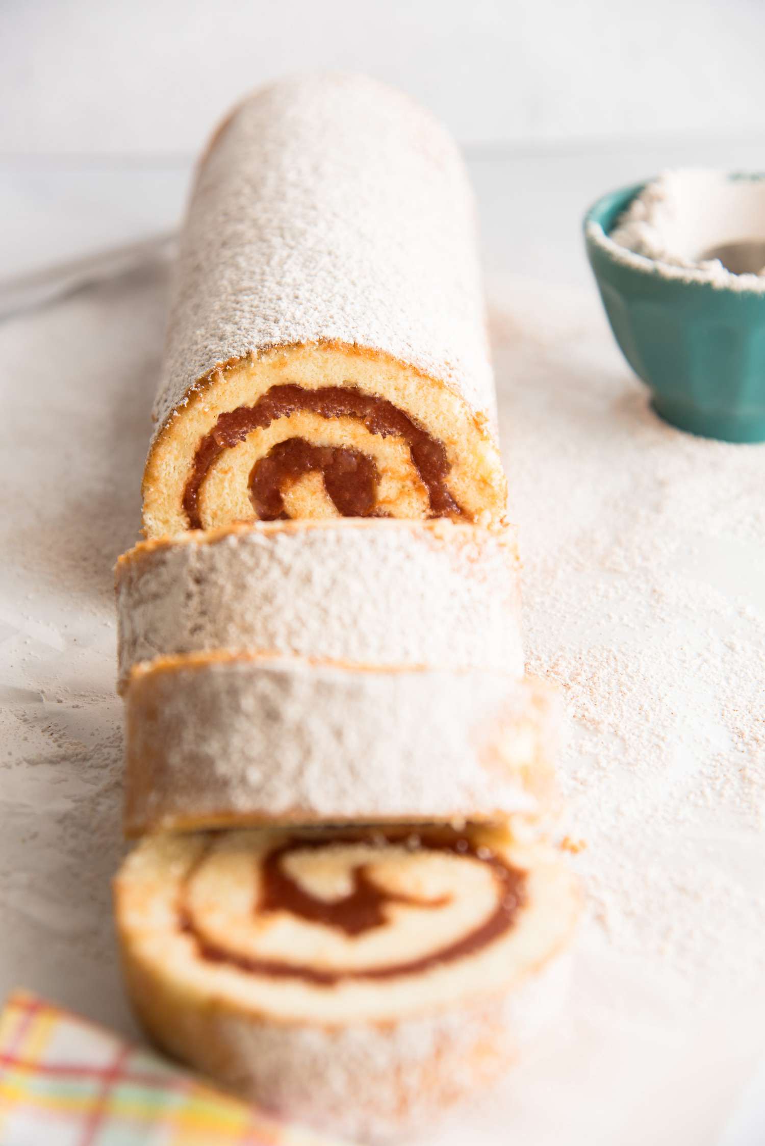 Roll Cake with Guava Jelly topped with powdered sugar and cut into a few slices.