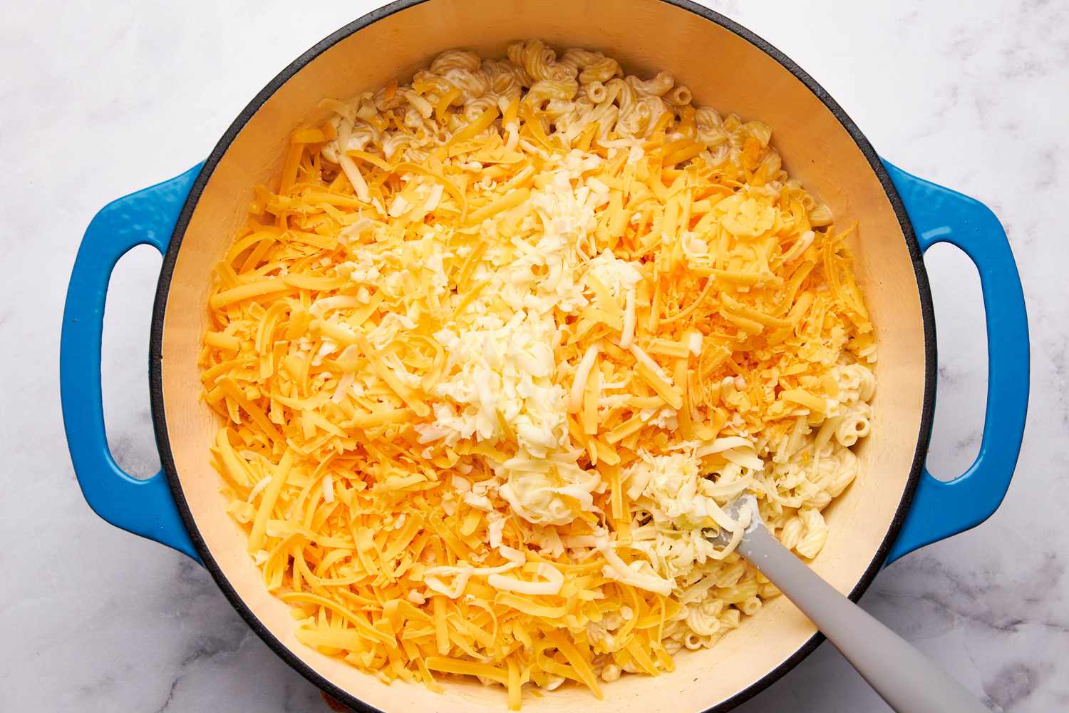 Shredded cheeses added to dutch oven for one pot mac n cheese recipe