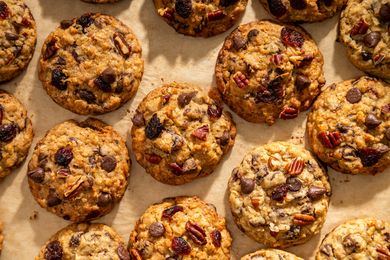 Rows of freshly baked ranger cookies with nuts chocolate chips and dried fruit as visible ingredients