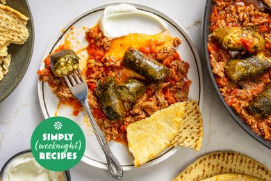 A plate of stuffed grape leaves with a side of flatbread and yogurt dip part of a Simply Weeknight Recipes presentation