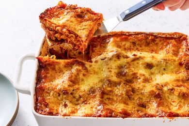 A serving of baked lasagna being lifted from a dish with a spatula