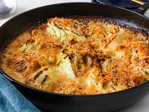 Angled view of a cast iron skillet of cabbage au gratin after baking