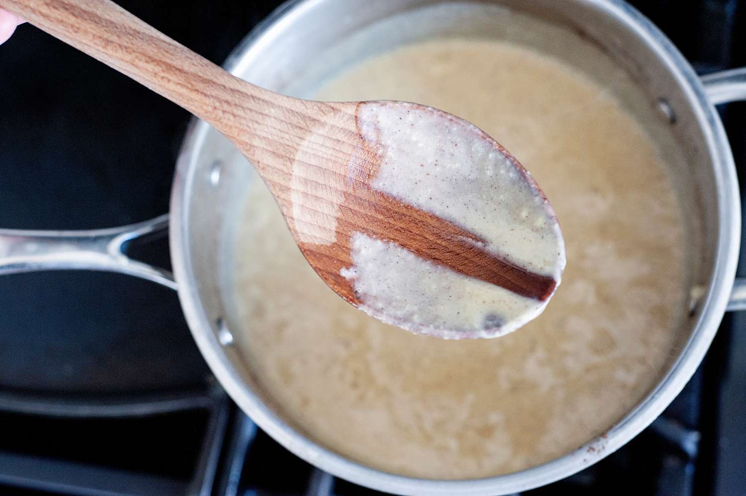 Cinnamon ice cream base thickening in a tall sided skillet.