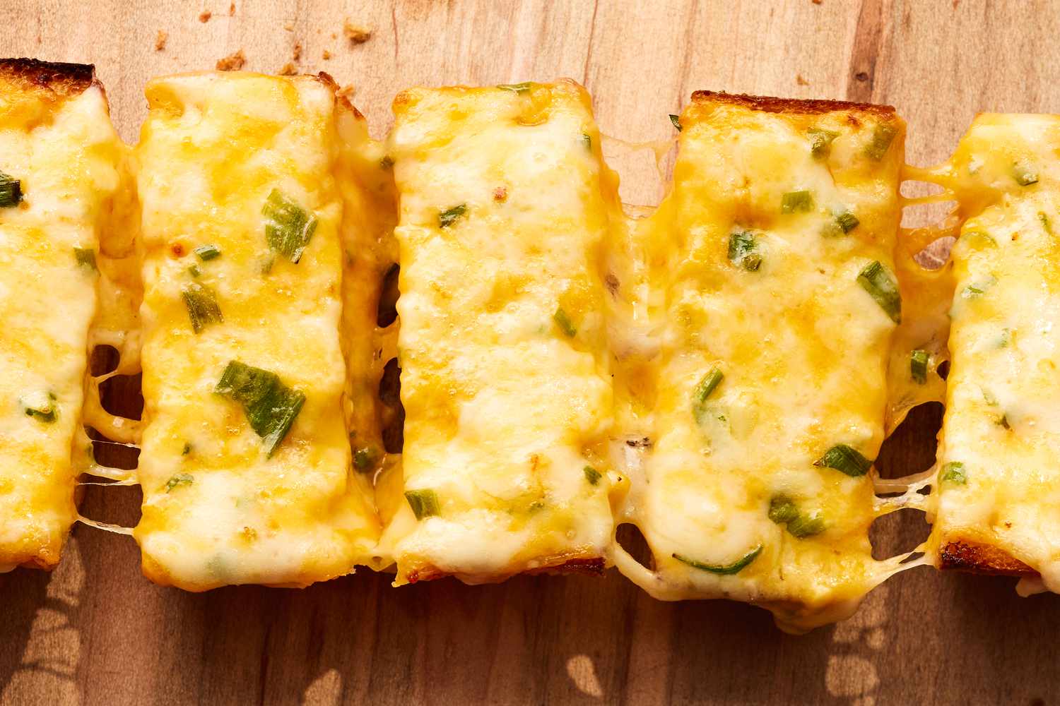 Close-up: Cheesy Bread Cut Into Slices and Slightly Pulled Apart to Create a Cheese Pull