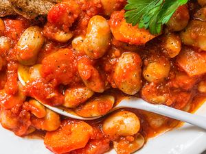 Beans in a tomatobased sauce served with a piece of toast and garnished with parsley