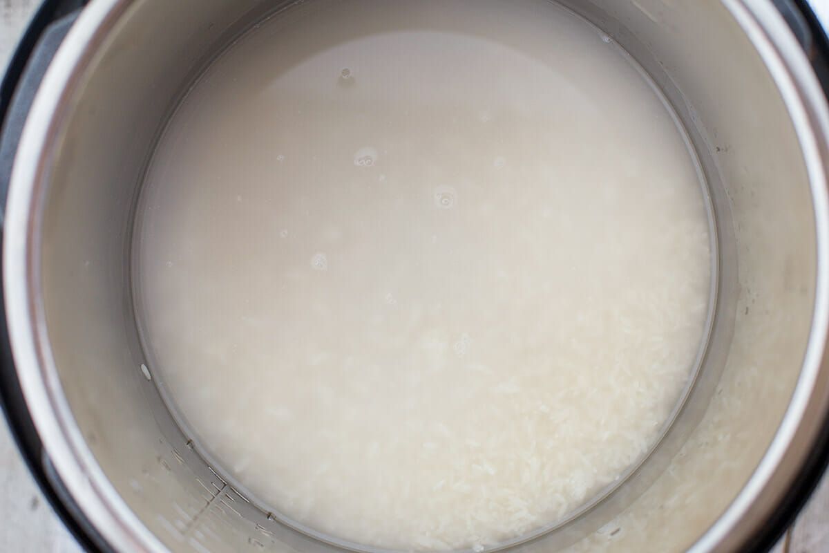 Raw rice and water in the cooker of an Instant Pot as seen from above