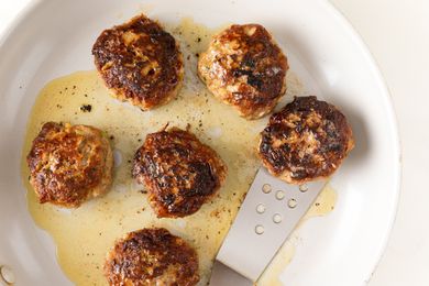 Plate of cooked German meatballs with a spatula