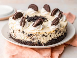 Oreo cheesecake decorated with whipped cream and Oreos on a plate