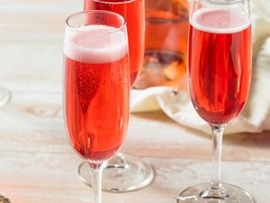 a red bubbly cocktail in a champagne glass