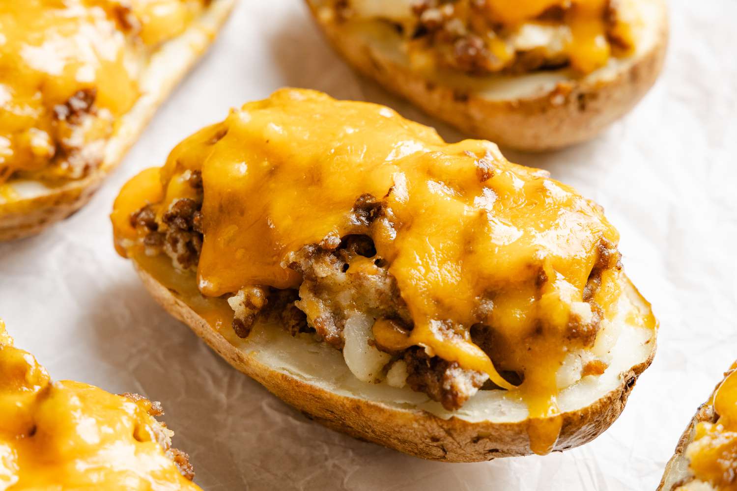Cheeseburger stuffed baked potatoes on parchment paper