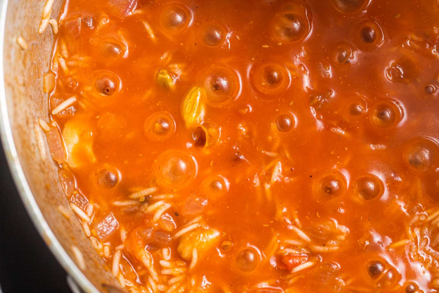 Rice and Tomatoes Boiling in a Pot