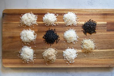 Piles of rice varieties on a wood chopping board