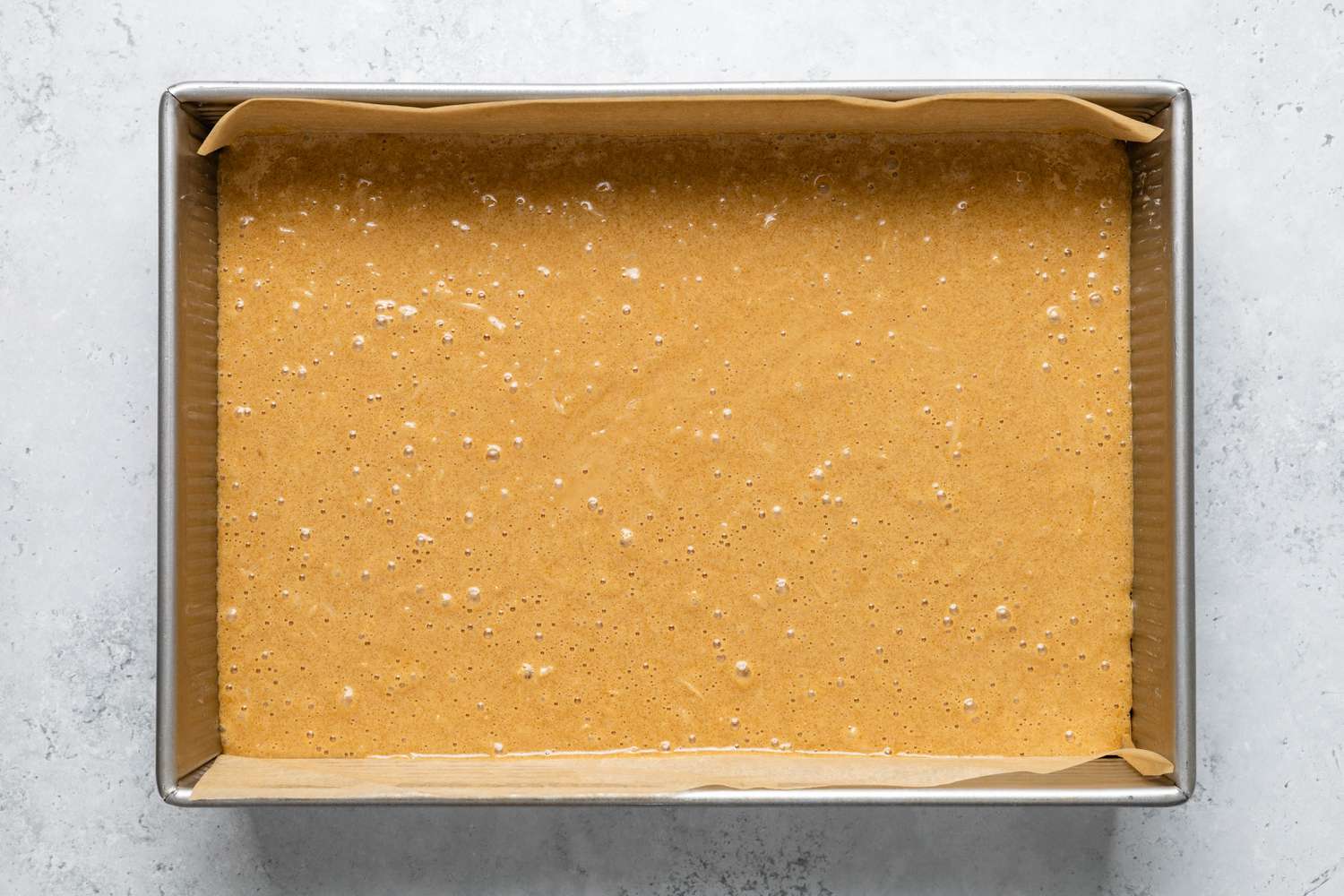 Sad Cake Batter in a Parchment Paper Lined Baking Sheet for Sad Cake Recipe