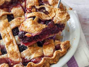 Blackberry Pie in a Pie Dish with a Slice Raised on a Pie Server