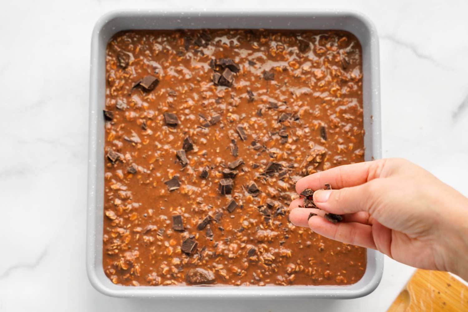 Vegan Brownie Baked Oatmeal Batter in the Baking Pan Topped with More Chopped Chocolate 