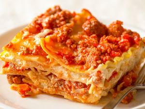 A slice of lasagna on a plate with a fork