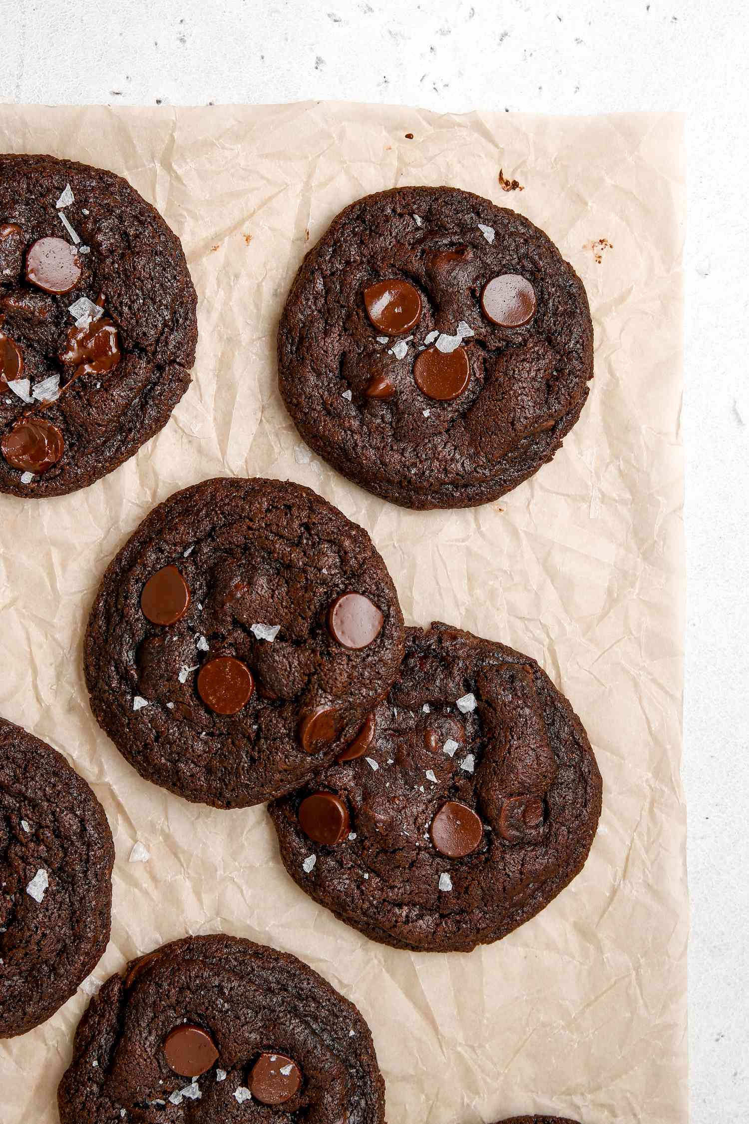 Chewy double chocolate cookies on a parchment lined baking sheet.