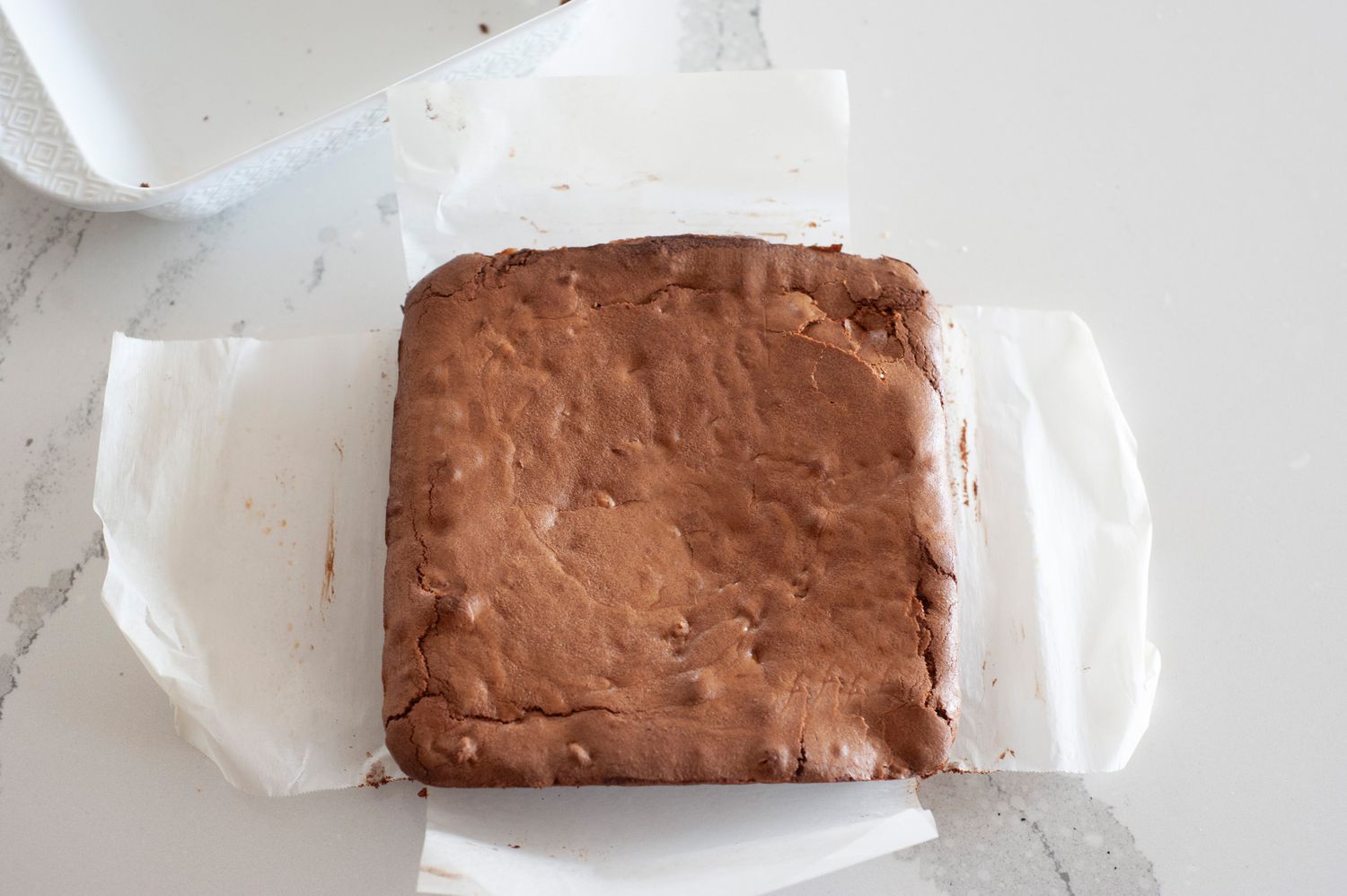Baked brownies on parchment paper.