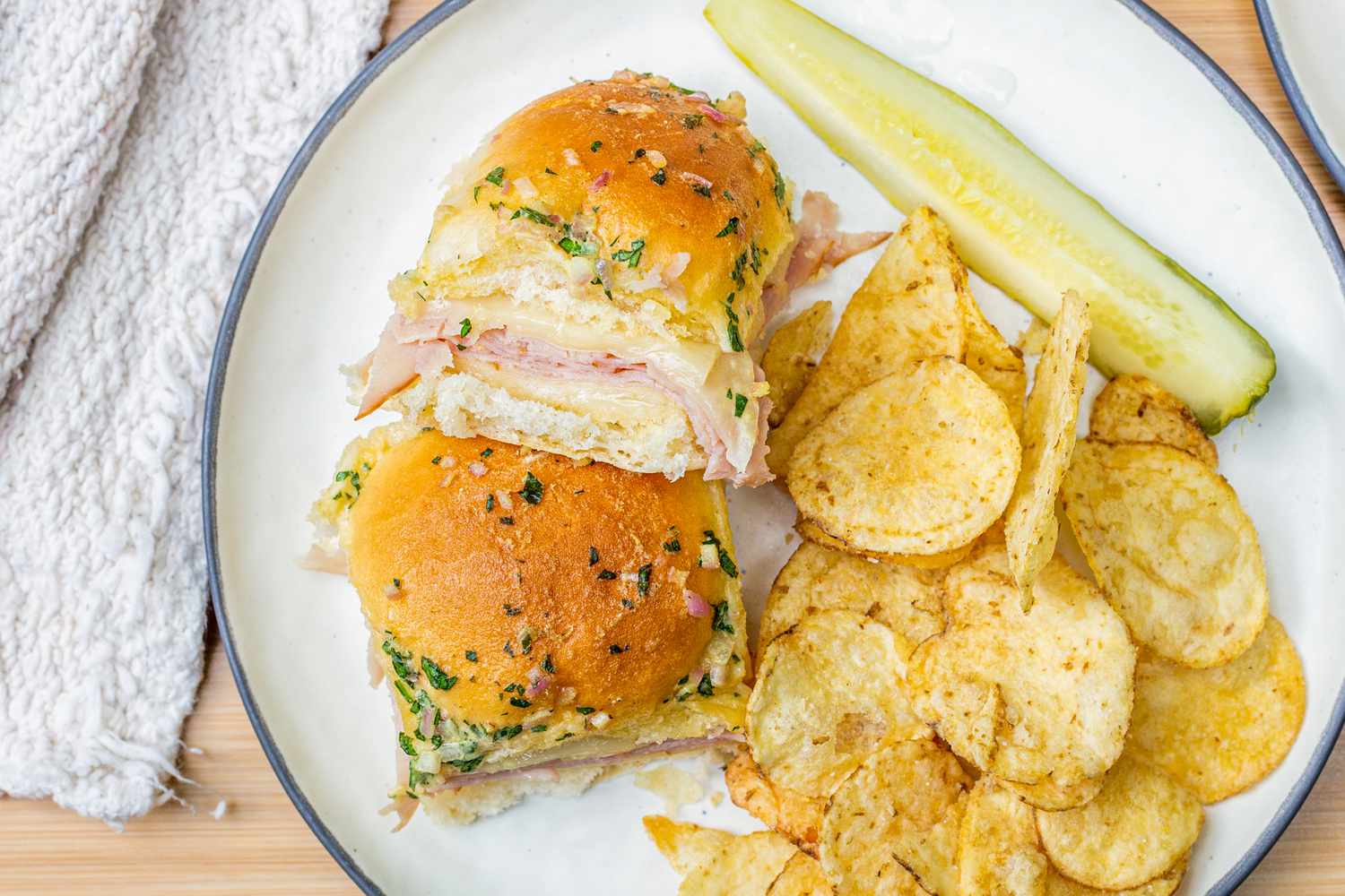 Plate of Hot Ham and Cheese Sandwiches with Chips and a Pickle