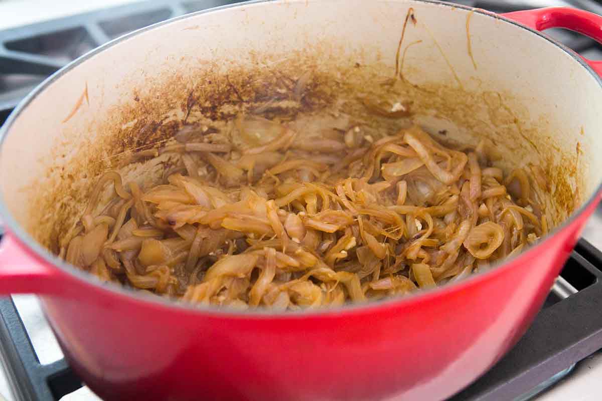 Onions cooking in a large, red pot