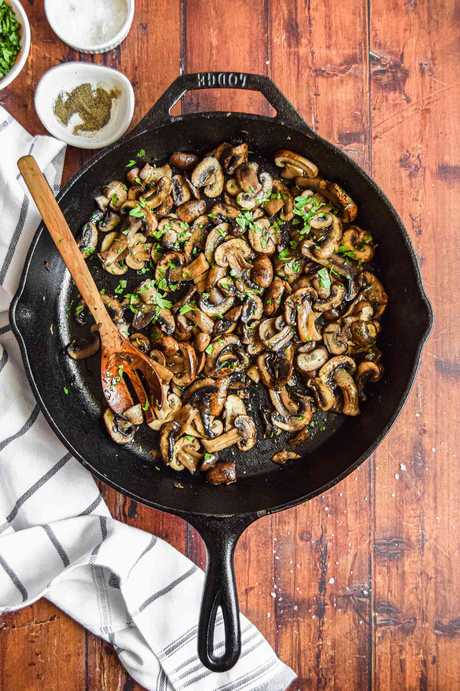 Mushrooms in a Cast Iron Skillet with a Spoon for A Better Way to Cook Mushrooms