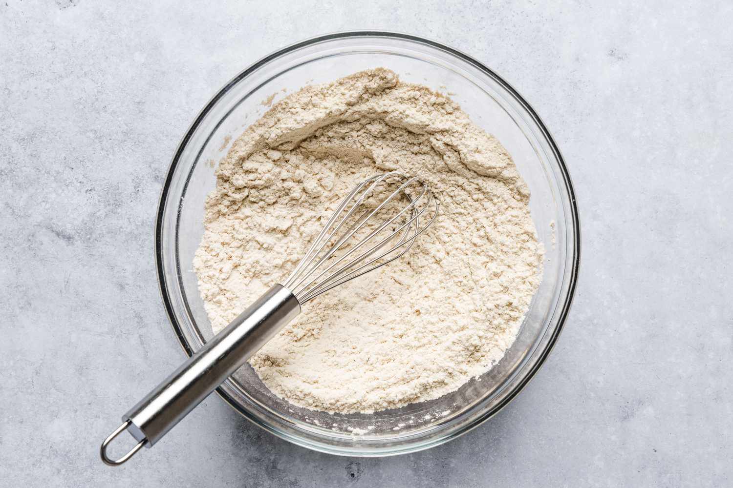 bowl with dry ingredients mixed together, whisk resting inside of bowl - Feather Cake