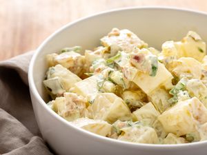 Side view of homemade potato salad in a white bowl.